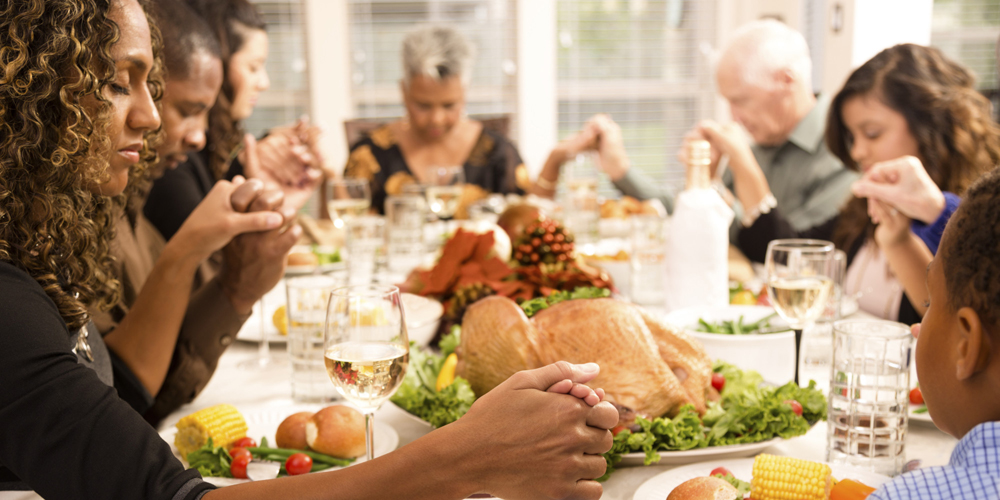 Thanksgiving:  Family prays during holiday dinner.